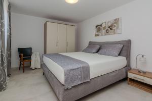 sypialnia z dużym łóżkiem i krzesłem w obiekcie Apartments Tukara w mieście Vir