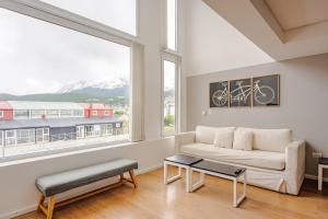 a living room with a white couch and large windows at Gray Fox Apartments - Deloqui in Ushuaia