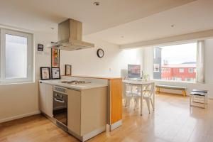 a kitchen with a stove top oven next to a table at Gray Fox Apartments - Deloqui in Ushuaia