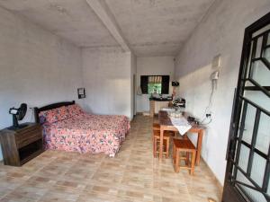 a bedroom with a bed and a table and a desk at Mini casa interior Teixeira in Augusto de Lima