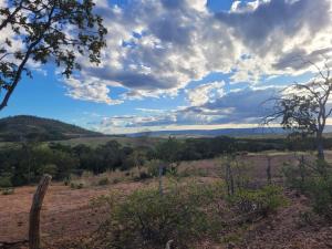 a view of a field under a cloudy sky at Mini casa interior Teixeira in Augusto de Lima