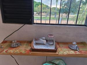 a table with a tray of towels and a window at Mini casa interior Teixeira in Augusto de Lima +1 photo