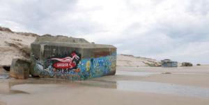 a wall with graffiti on it on the beach at Appartement cosy in Naujac-sur-Mer +2 photos
