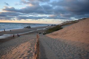a group of people walking on a sandy beach at Appartement cosy in Naujac-sur-Mer