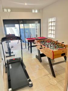 a room with a foosball table and a treadmill at Maison Lumineuse à 15km de paris in Villiers-le-Bel