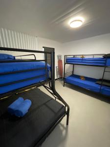 two bunk beds in a room with blue sheets at Tahiti Sunshine in Papeete