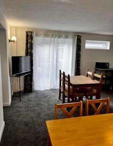a living room with a table and a television at St Joseph's Guest House in Southampton +40 photos