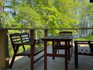 a wooden table and two chairs on a deck at Leonówka in Jegliniec