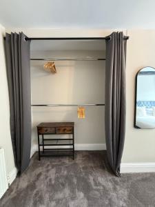 a room with curtains and a table and a mirror at St Matthews View in Halifax