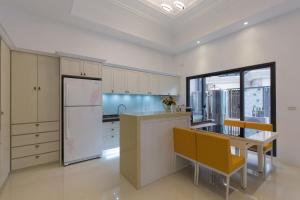 a kitchen with a refrigerator and a table and chairs at Creekside No.22 B&B in Jiali