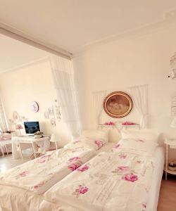 a bedroom with a white bed with pink flowers on it at Seeseite-Romantik-Apartment in Timmendorfer Strand