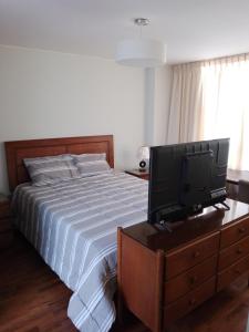 San AntonioMiraflores, Lima, habitación independiente的卧室里有一张床和一台放在梳妆台上的电视