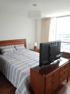 1 dormitorio con cama y vestidor con TV en Miraflores, Lima, habitación independiente, en San Antonio