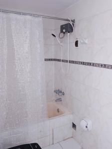 Un baño con ducha, bañera y WC. en Miraflores, Lima, habitación independiente, en San Antonio