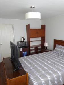 Un dormitorio con una cama y un televisor de pantalla plana. en Miraflores, Lima, habitación independiente, en San Antonio