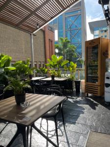een patio met tafels, stoelen en planten bij Hotel bh El Poblado in Medellín