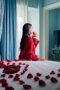 a woman sitting on a bed with roses on the bed at Kempinski Nile Hotel, Cairo in Cairo