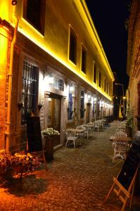 a cobblestone street with chairs and tables at night at Orchis Hotel in Ayvalık