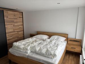 a bedroom with a bed with white sheets and pillows at Ferienhaus Wellenperle in Dornumersiel