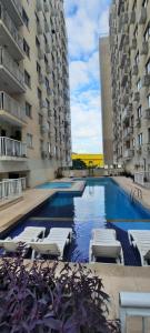 a swimming pool with lounge chairs and two buildings at Splendido Niterói Quarto Aconchegante com Banheiro Só Seu - Anfitrião mora no local in Niterói