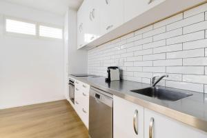 a kitchen with a sink and a counter top at Spacious 3BR Retreat on City Fringe w Free Parking in Wellington +15 photos