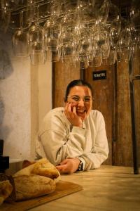 ein Mann, der an einem Tisch unter Weingläsern sitzt in der Unterkunft Putechella Retro Rooms & Villa in Tramonti + 25 Fotos