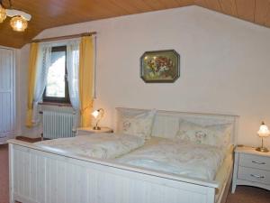 a bed in a bedroom with two lamps and a window at Gästehaus Steiger in Bad Birnbach