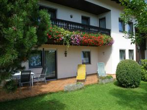 a house with a balcony with chairs and flowers at Gästehaus Steiger in Bad Birnbach