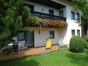 ein Haus mit einem Balkon mit Stühlen und Blumen in der Unterkunft Gästehaus Steiger in Bad Birnbach