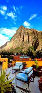 a patio with two benches and a mountain in the background at Mountainview House Ollantaytambo in Ollantaytambo