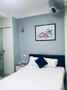 a bedroom with a white bed with a blue wall at Linh Anh Hotel in Hanoi
