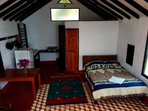 a bedroom with a bed and a table and a desk at Cuarto 2 in San Marcos La Laguna