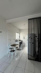 a kitchen with a table and chairs and a refrigerator at Condomínio Jardim Presidente 08 in Cuiabá