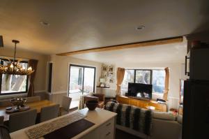 a living room with a couch and a dining room at Mountain Retreat Suitable for 2 Families, Sleeps 8 in Mount Buller