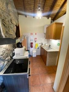 a small kitchen with a sink and a refrigerator at Refúgio Rural no Gerês - Casa Araujo de Sousa in Terras de Bouro +39 photos