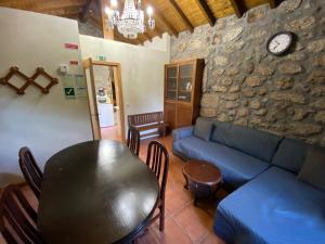 a living room with a blue couch and a table at Refúgio Rural no Gerês - Casa Araujo de Sousa in Terras de Bouro