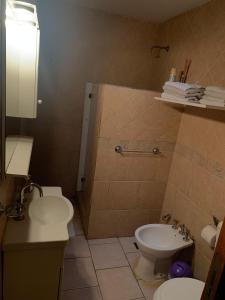 a bathroom with a toilet and a sink at Lo de Mary in Villa Elisa +15 photos