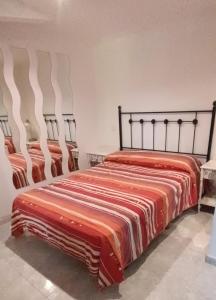 a bed with a striped blanket on it in a room at Apartamento Flor de Luna in Santillana del Mar