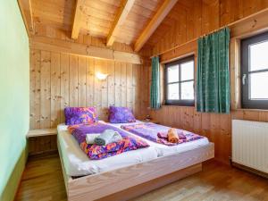 Un dormitorio con una cama en una cabaña de madera. en Schweizerhof Arnika, en Huben