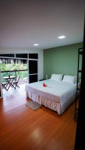 a bedroom with a large white bed and a wooden floor at Flat do Tubanoronha in Fernando de Noronha