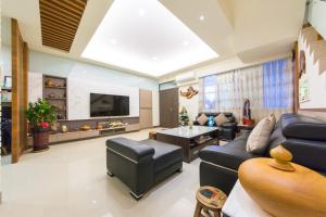 uma sala de estar com um sofá azul e uma televisão em Jerry B&B em Taitung City