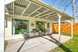 a covered patio with two chairs and a table at 6 Mi to Clear Lake Family Home with Patio and Yard in Webster
