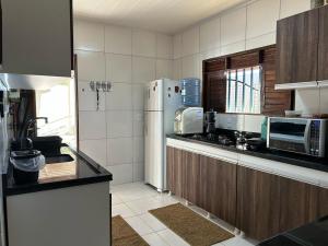 a kitchen with a refrigerator and a counter top at Casa Brilho do Sol in Zumbi