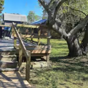 a group of wooden benches sitting under a tree at A Perfect Family Getaway in Pensacola
