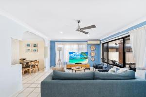 a living room with a blue couch and a table at Tweed Escape in Tweed Heads
