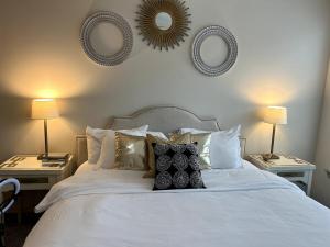弗赖拉辛2 BR Heart of Frisco Gem的卧室配有一张带两盏灯和镜子的白色床。 更多28张照片