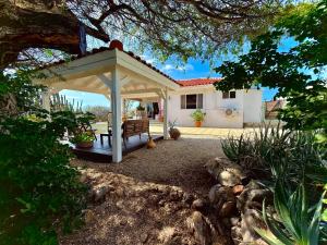 努尔德Mila's Authentic Family Getaway Aruba的房屋前带长凳的亭子