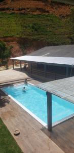 Una piscina con una mesa de picnic y una persona en ella. en Espaço de Festas e Eventos Elefante, en Domingos Martins