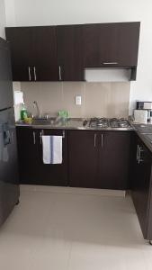 a kitchen with dark brown cabinets and a sink at atardeceres in Armenia