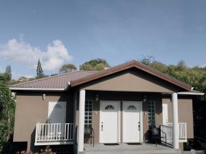een klein huisje met witte deuren en een veranda bij Itopia in Gros Islet